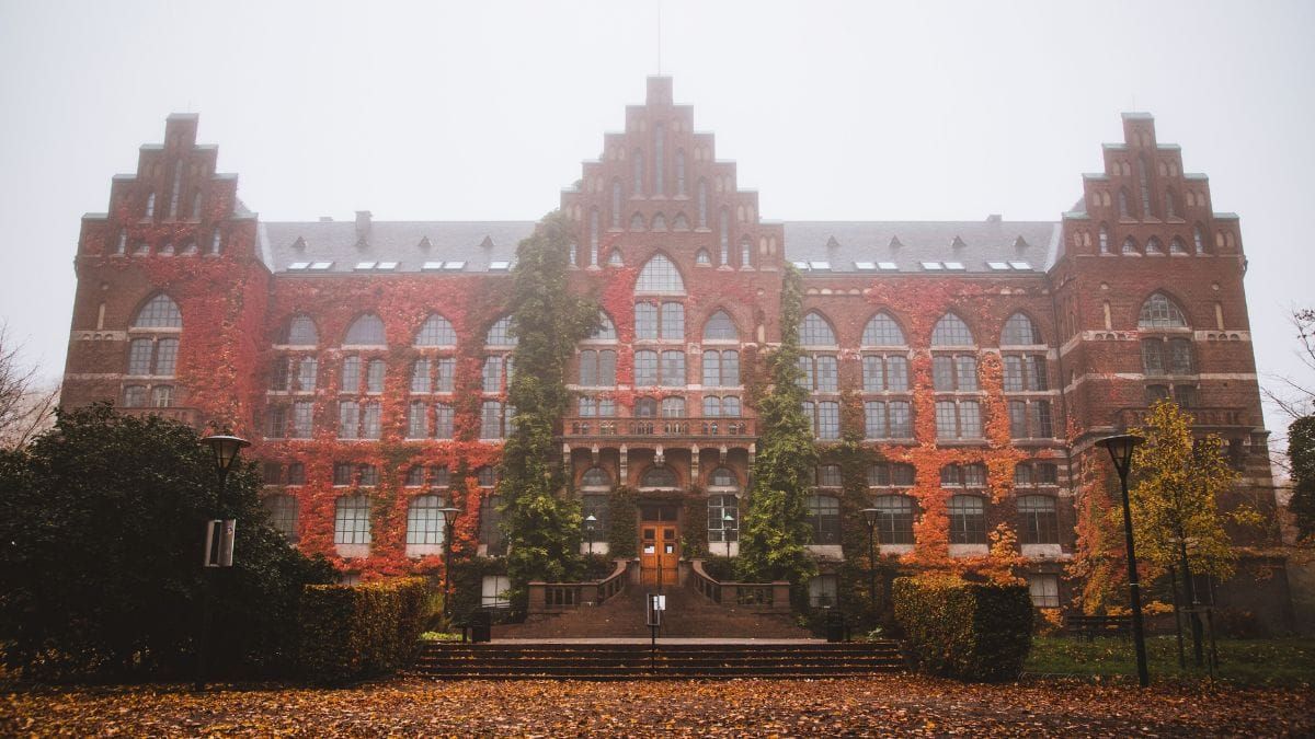 Historic university building covered in red autumn ivy