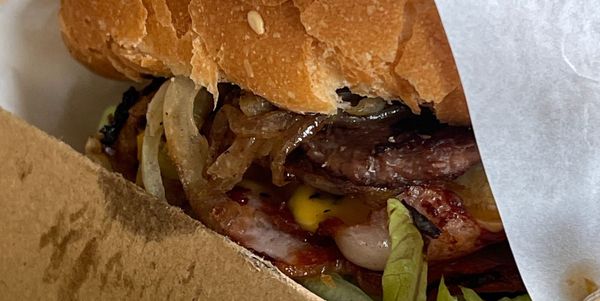 Zoomed in photo of a takeaway shop works burger. It looks fucking amazing.