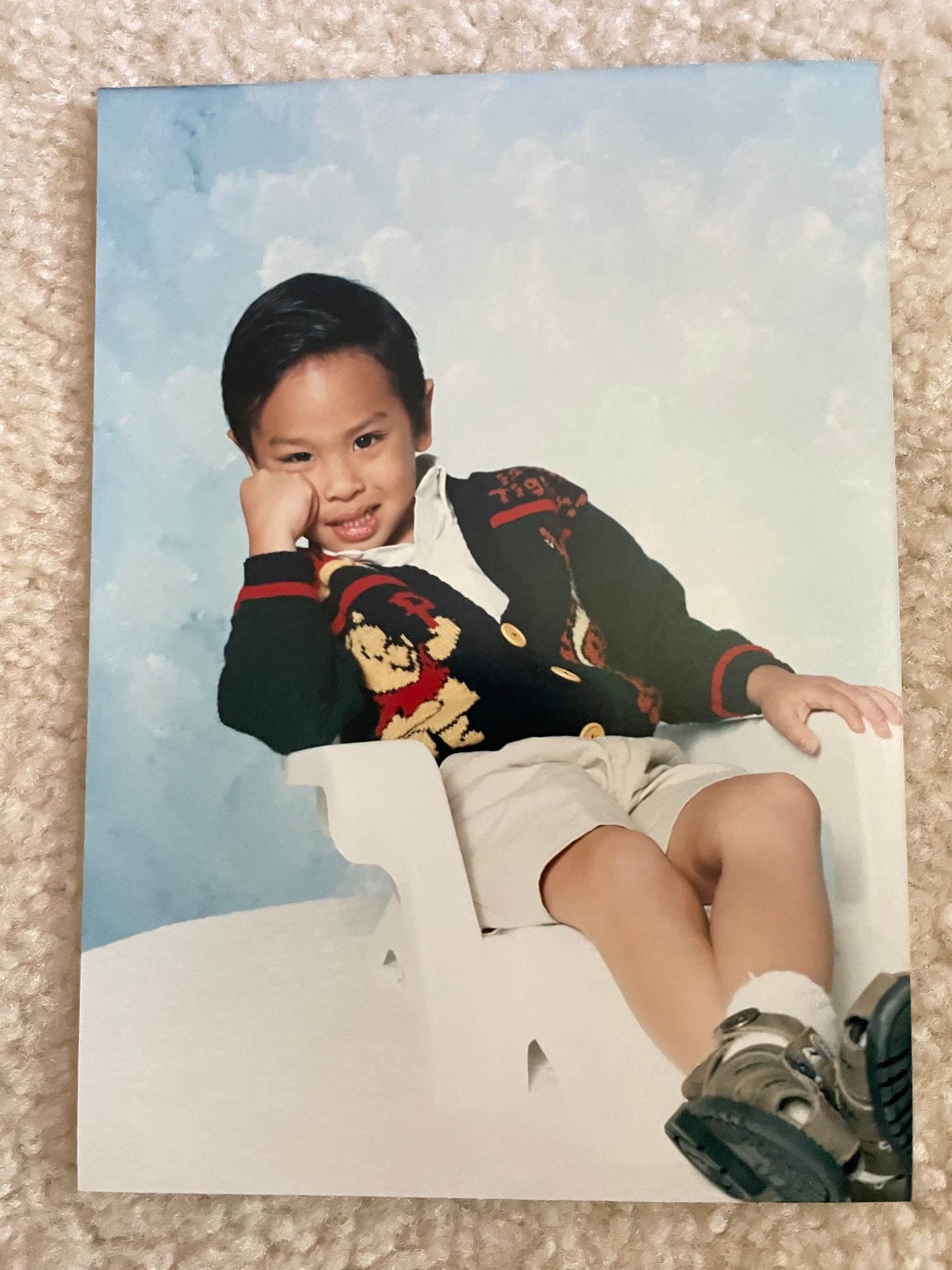 A photograph of Cean Gamalinda as a young boy rests on beige carpet. 
