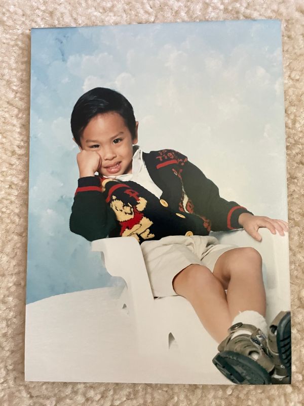 A photograph of Cean Gamalinda as a young boy rests on beige carpet. 