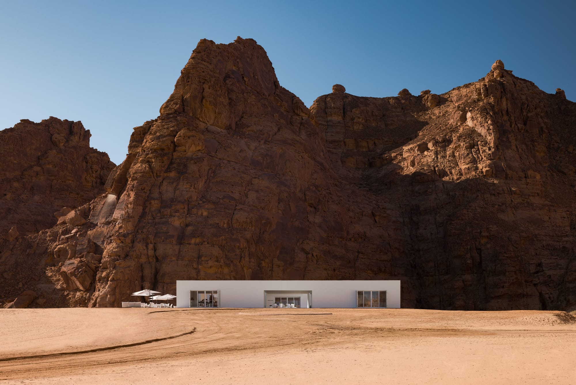 The 2022 Desert X visitor center against a shadowy rock backdrop
