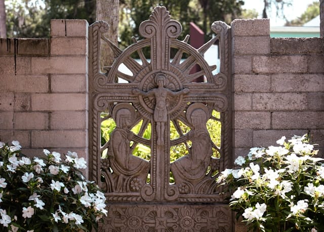 A concrete relief of Mary and John at the foot of the Cross.