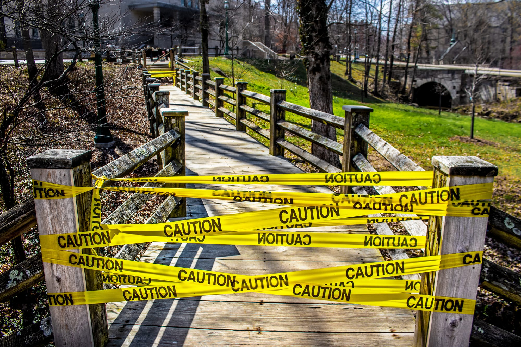 image of a walkway on a university that is being blocked with yellow caution tape