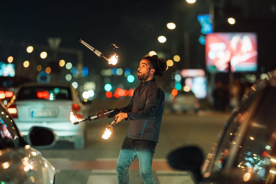 man juggling fire sticks