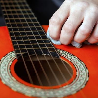 wiping a guitar with a cloth