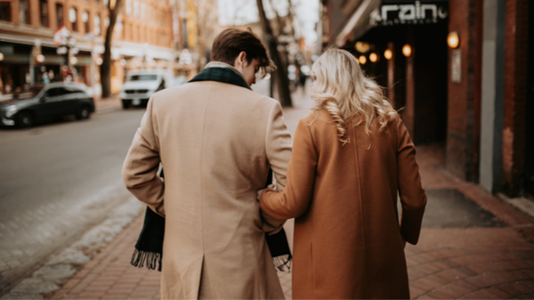 image: man and woman with linked arms, walking down the street; article: free song for september