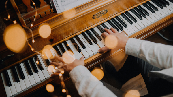 child playing piano with holiday lights