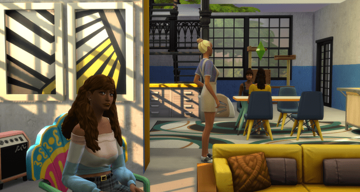 A screenshot of the Sims 4 depicting a woman sitting on a chair in a hip looking living room, kinda like the one I used to live in and blog in, in my twenties