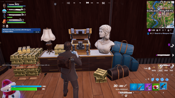 Alan Wake in Fortnite standing before a pile of gold bars and a treasure chest. There's a white stone bust and a lamp on either side of the treasure chest