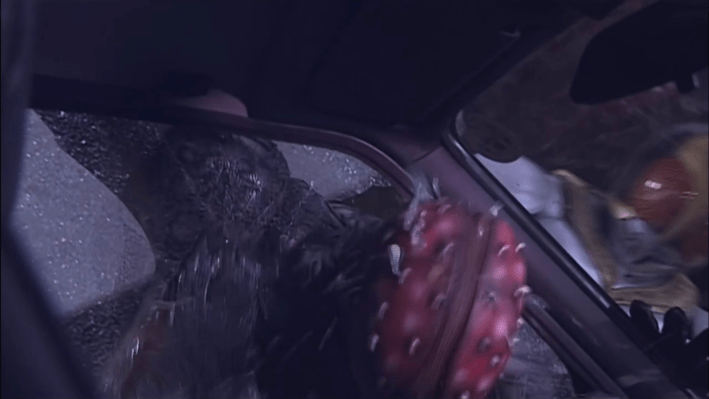 Kamen Rider Kuuga's Yusuke smashing a villain's head into a car window.