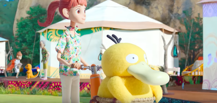 Psyduck in the basket of a scooter, looking slightly alarmed.