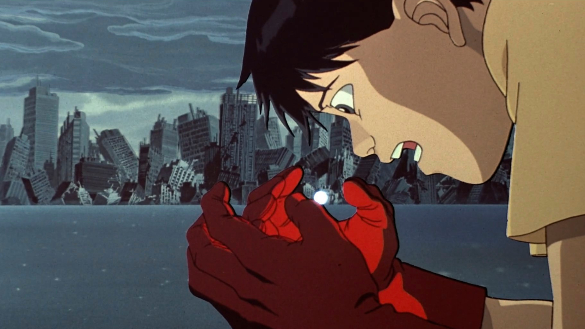 Akira's Kaneda clasping a small, glowing ball of light in front of a destoyed city.