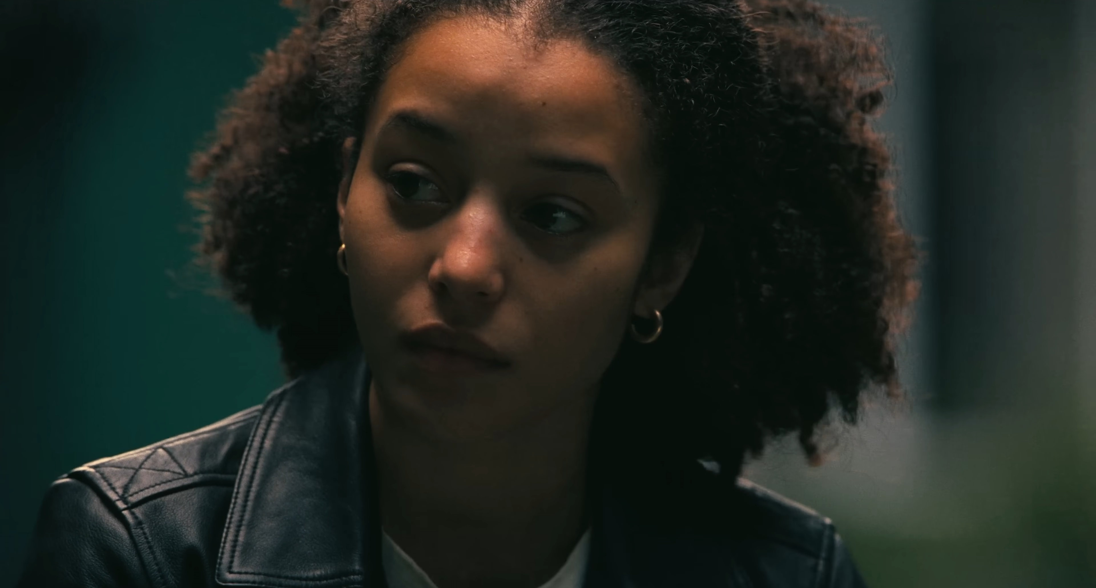 Chase Infiniti as Willa in One Battle After Another. She is looking to the left, concerned.