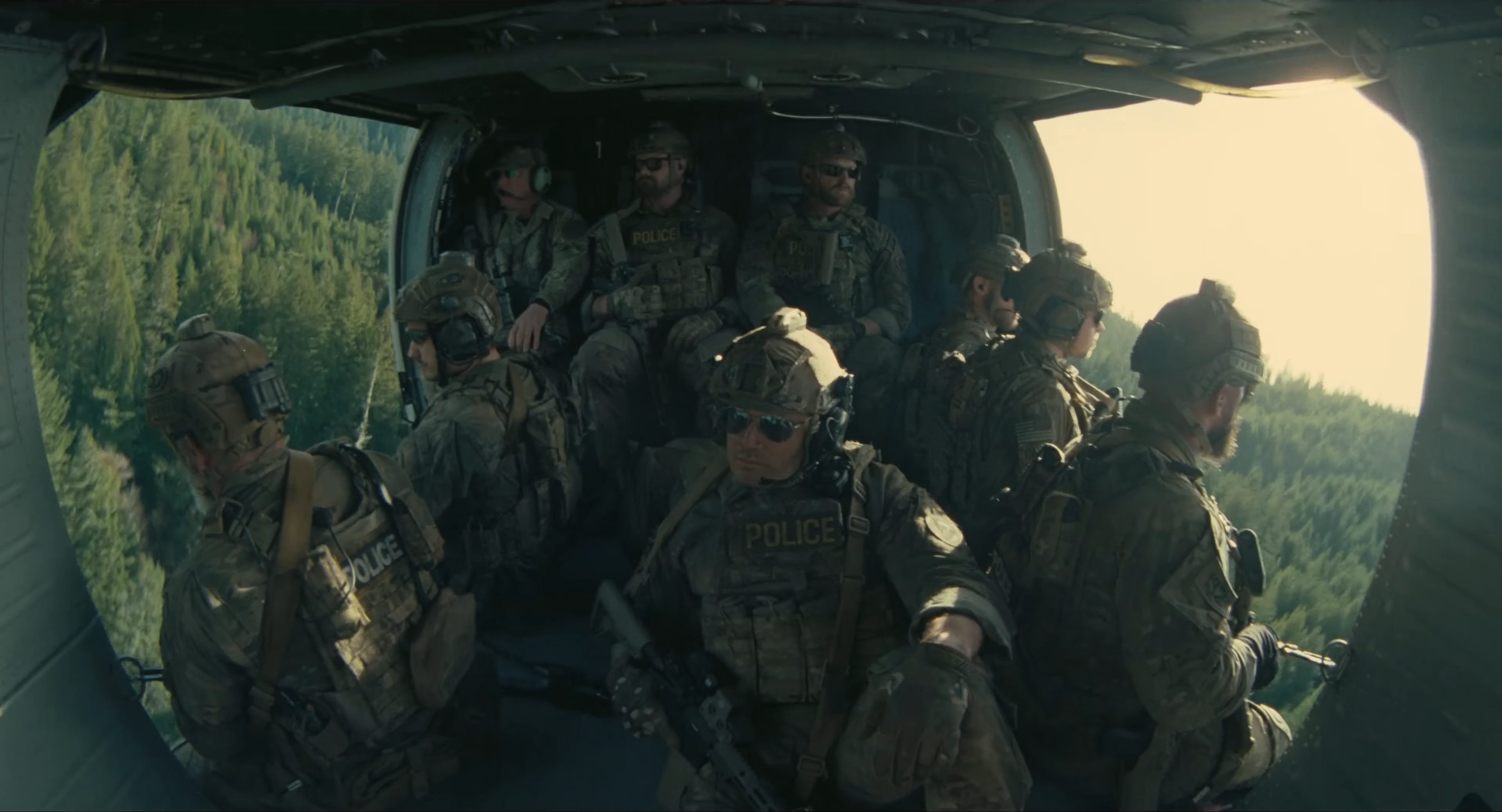 Police in a chopper, shot from the interior, over the woods.