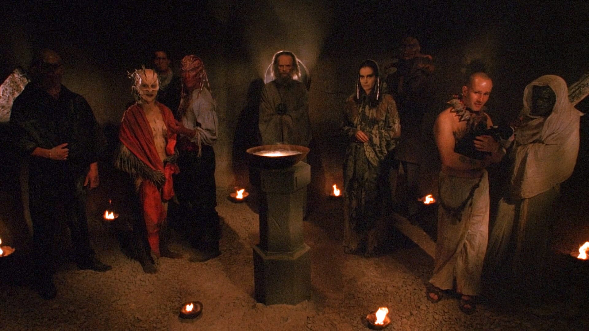 A collection of monsters surround a bowl with light emanating in the center.