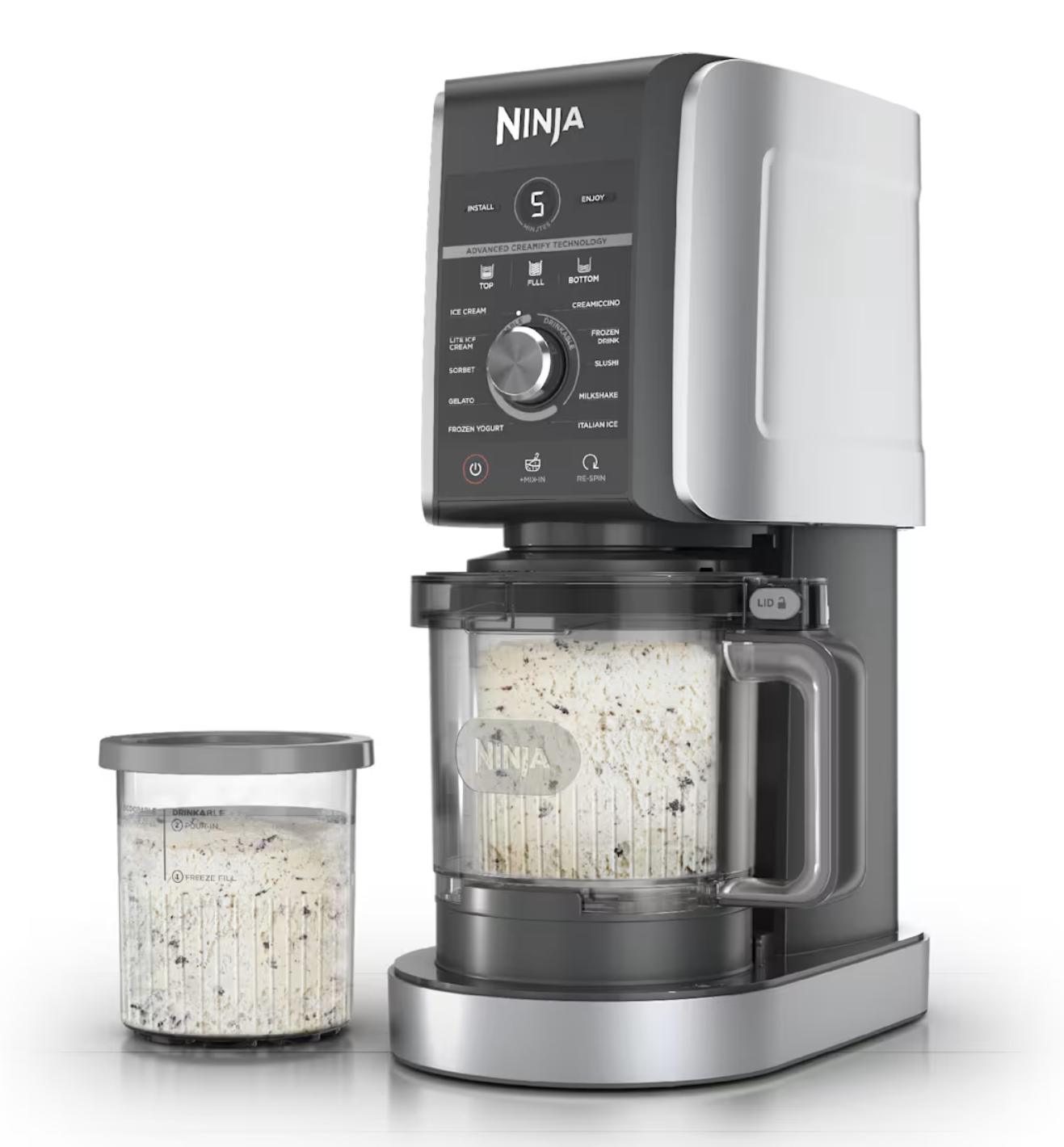 A creami next to a pint of something like cookie dough ice cream. The machine also contains such a pint..