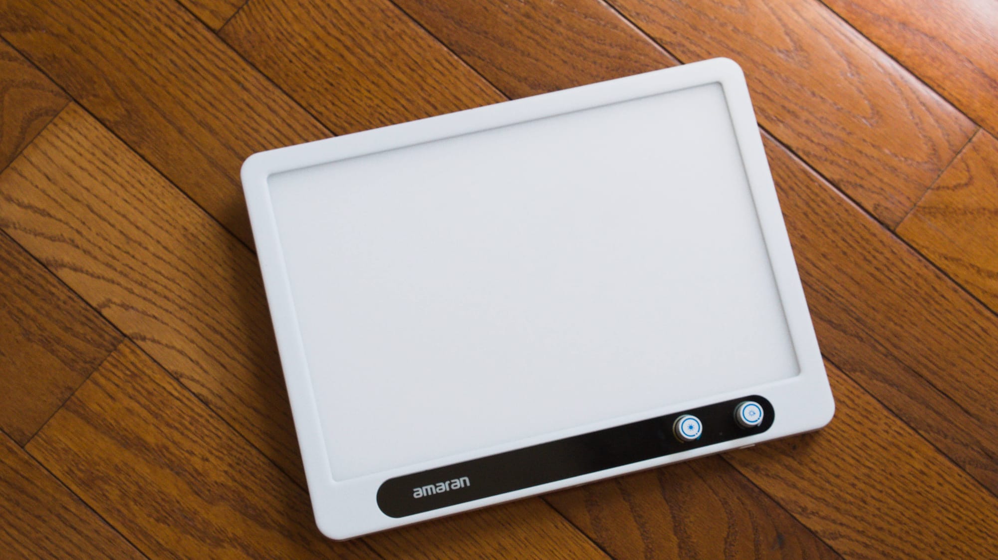 A white light panel on a wood surface.