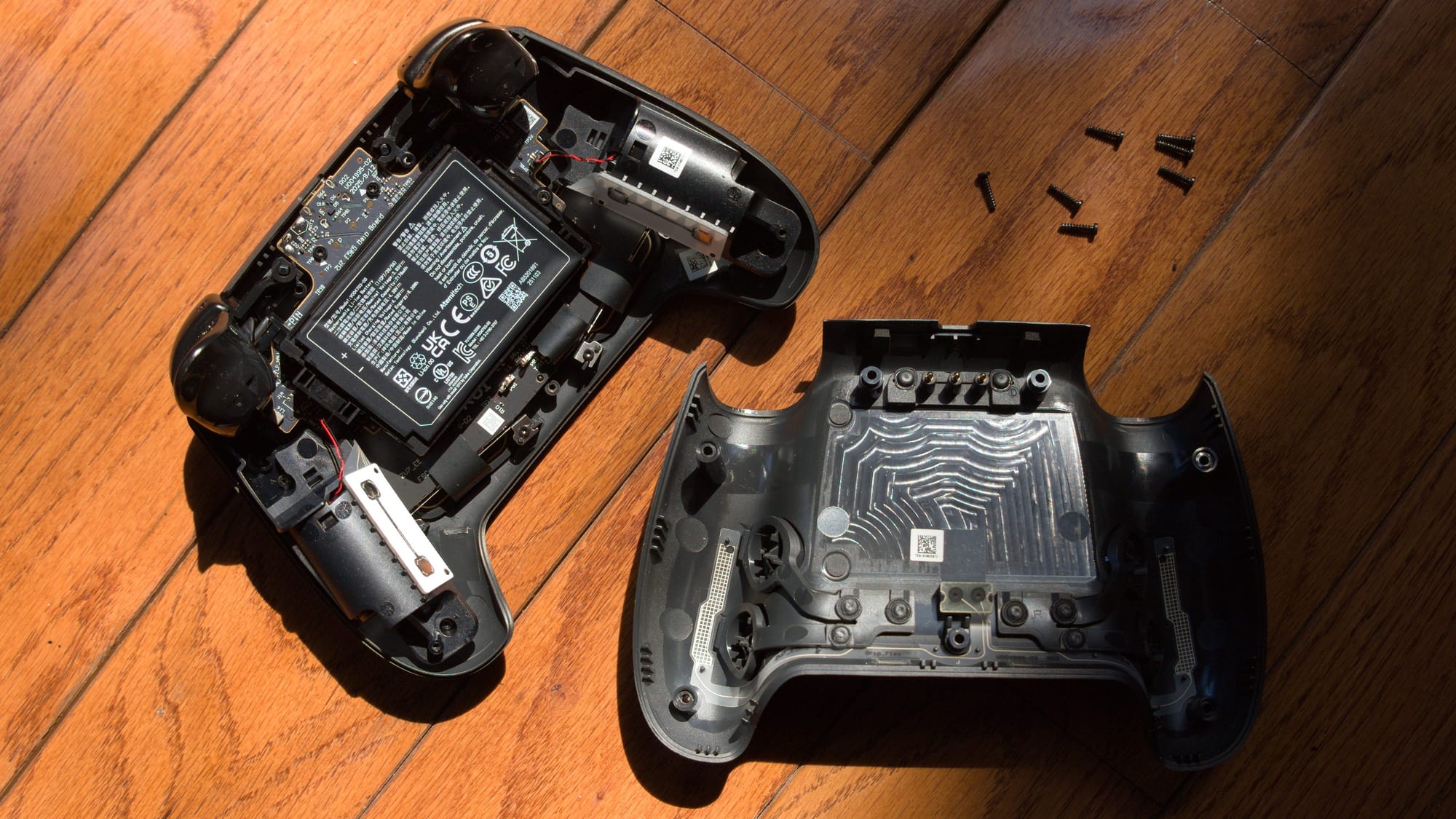 A controller lies open with 7 screws next to it, the battery is easily accessible.