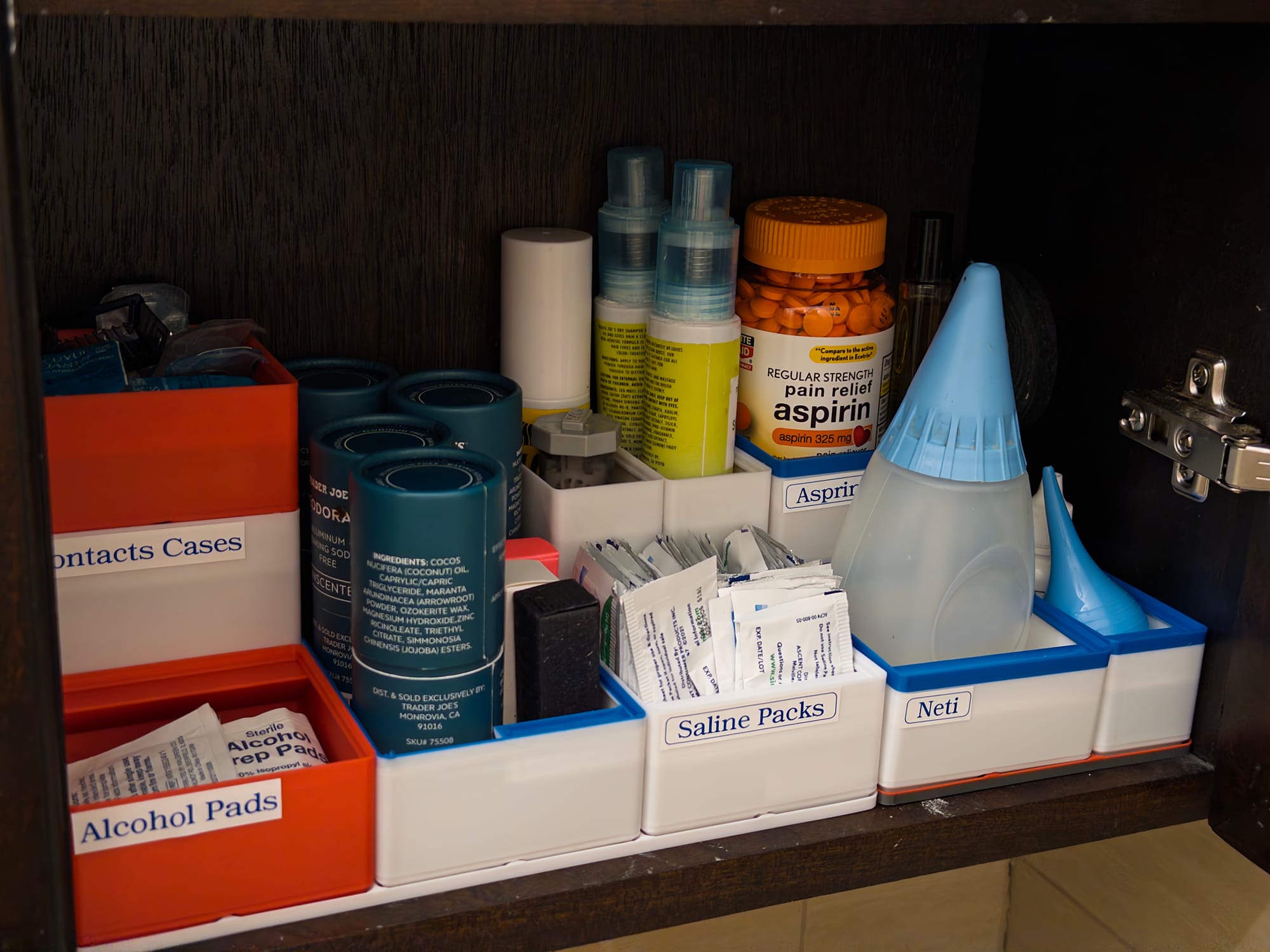 A bathroom vanity where all the items are stored in modular boxes that are labeled.