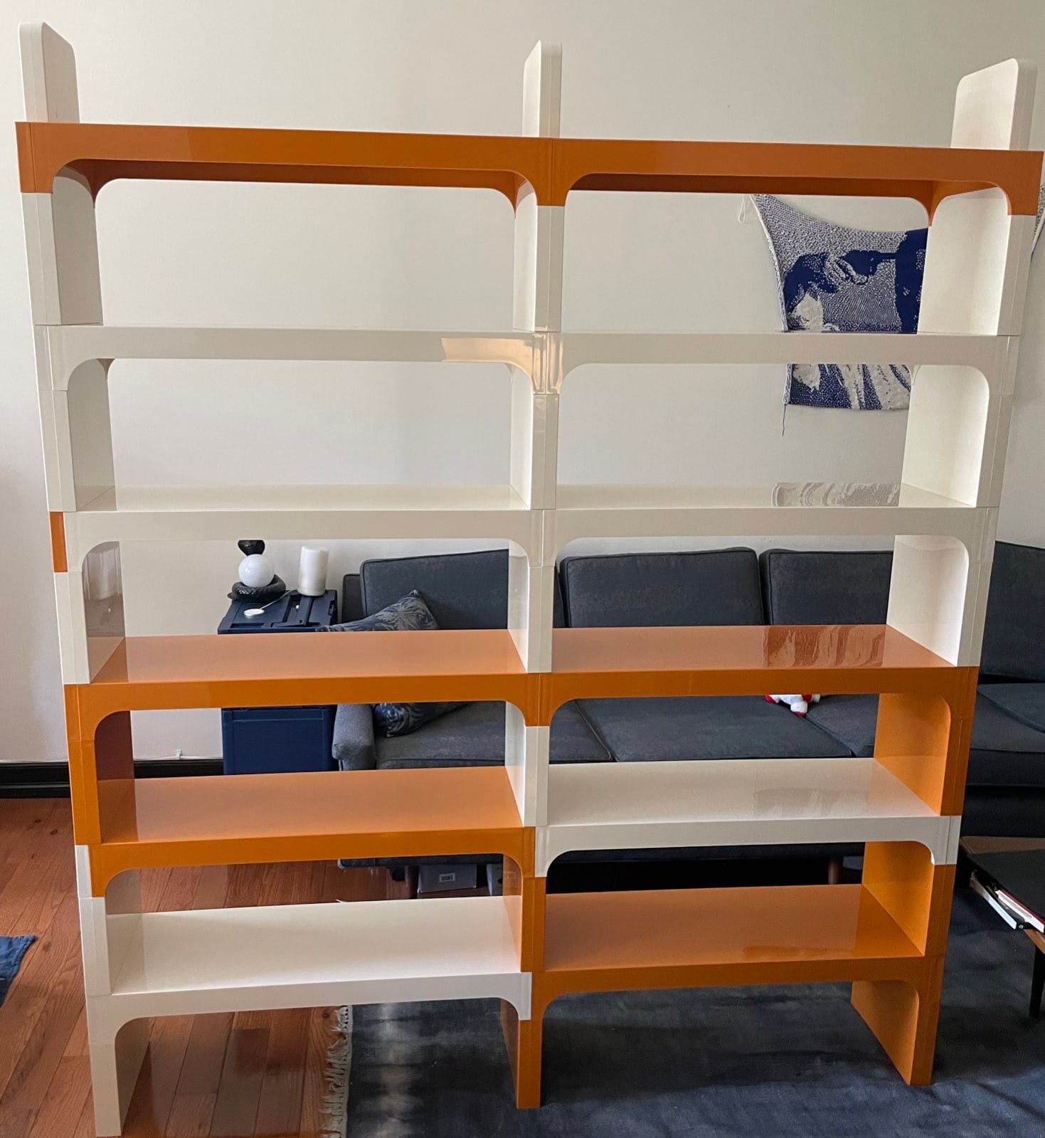 Orange and white shelves on a blue rug.
