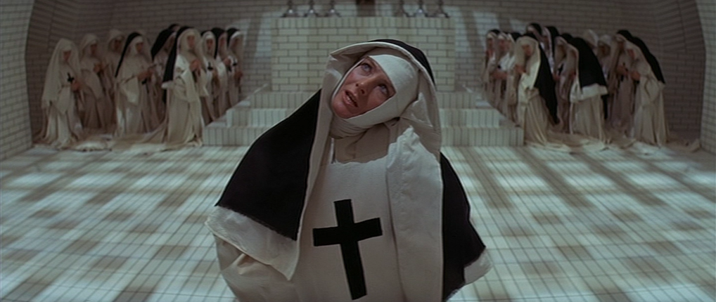 A nun turning her head while other nuns cower in fear.