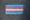 A trans flag, made of blue, pink, and white stripes, in chalk on black pavement