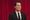 Agent Dale Cooper (Kyle MacLachlan) a man in a black suit, stares off into the middle distance in front of a red curtain.