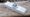 A long rectangle with a trackball in the middle and a dial surrounding the ball. There are six buttons on it. M1/M2. Then 01/02/03/04. It is on an old wood rail.