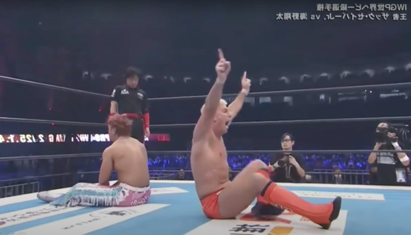 Zack Sabre, Jr. and Shota Umino both seated on the man in the middle of their title match at Wrestle Kingdom 19