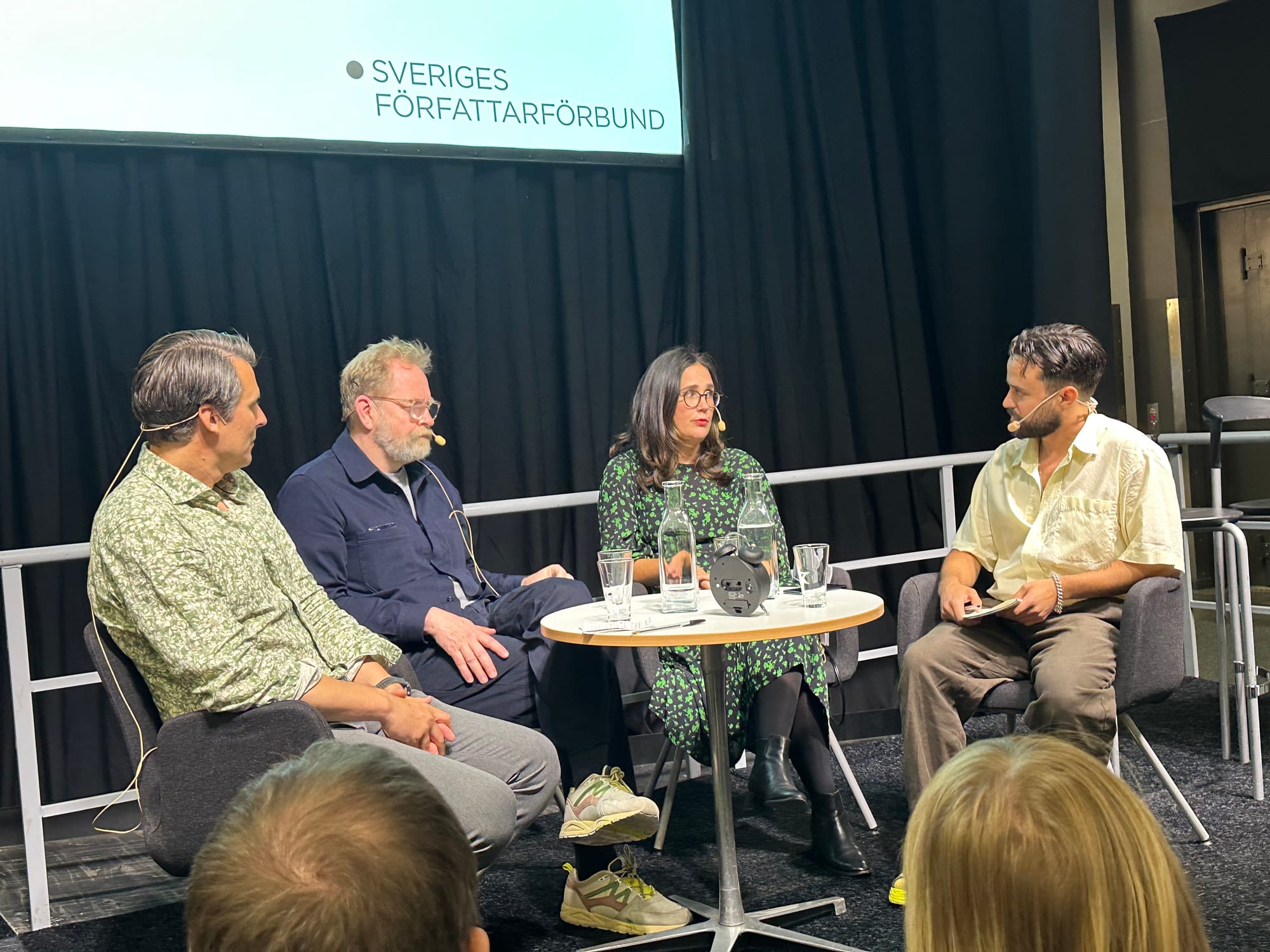 Bild av paneldeltagarna på scen vid ett runt bord. 