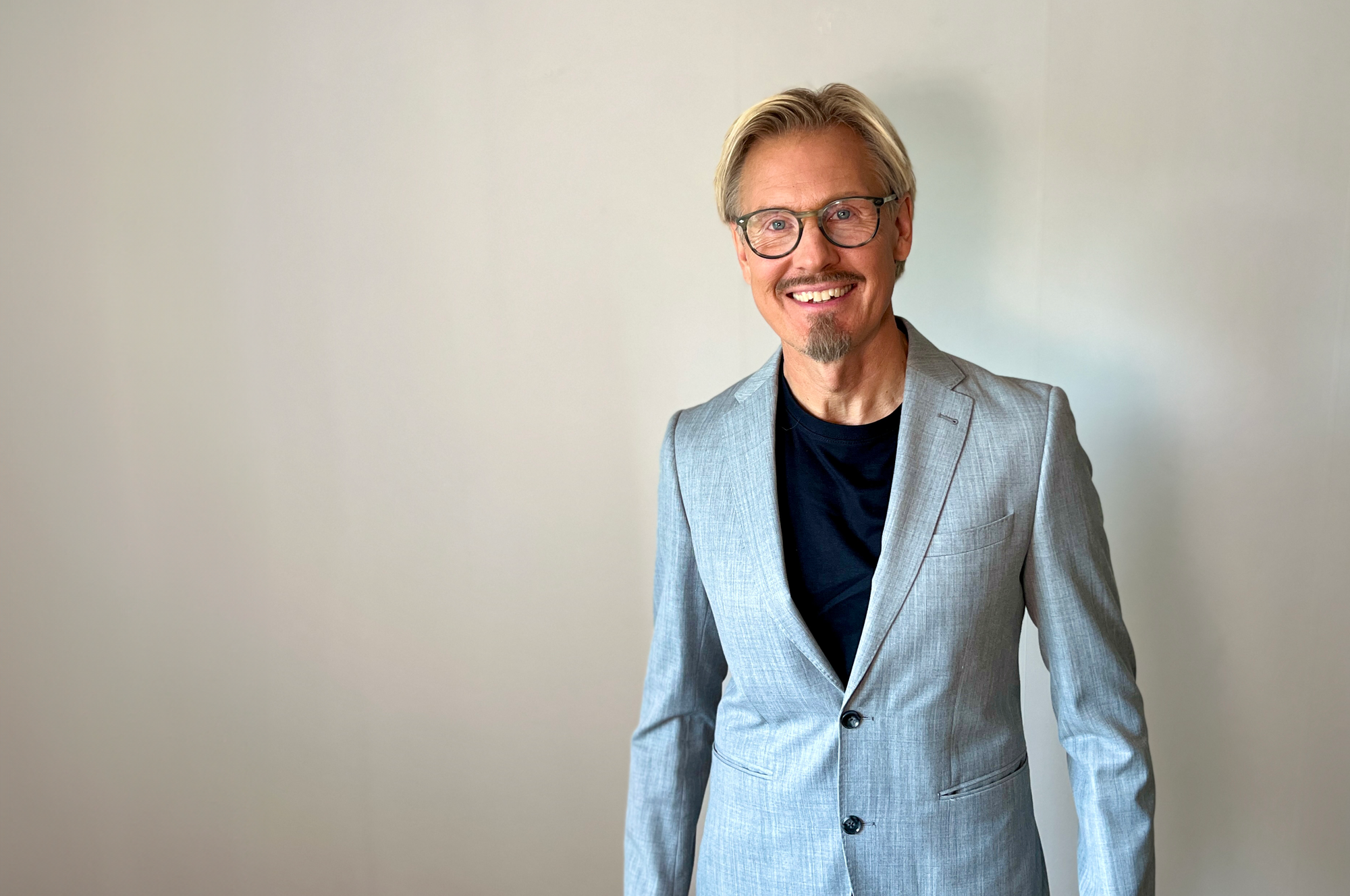 En bild på Fredrik Lundblad, kommunikatör på Sensus, iklädd blå kava mot en vit bakgrund.