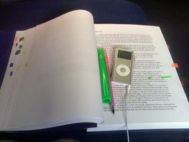 A manuscript with a pen, highlighter, and an iPod nano I won in a writing contest laying on a train tray. I was going to Chicago from Milwaukee. 