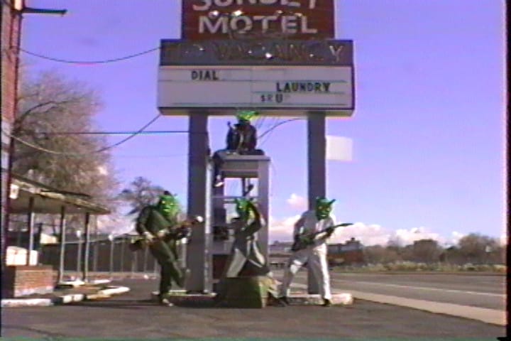 Rotary Club in front of a broken down motel’s sign atop a phone booth