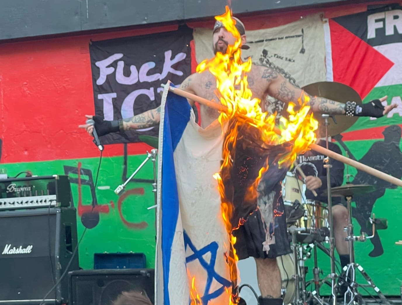 Haram performing at Herbert Von King Park in Bed-Stuy, Brooklyn (September 11, 2025) while someone burns an Israeli flag at the front of the stage; photo by Matthew Ismael Ruiz 