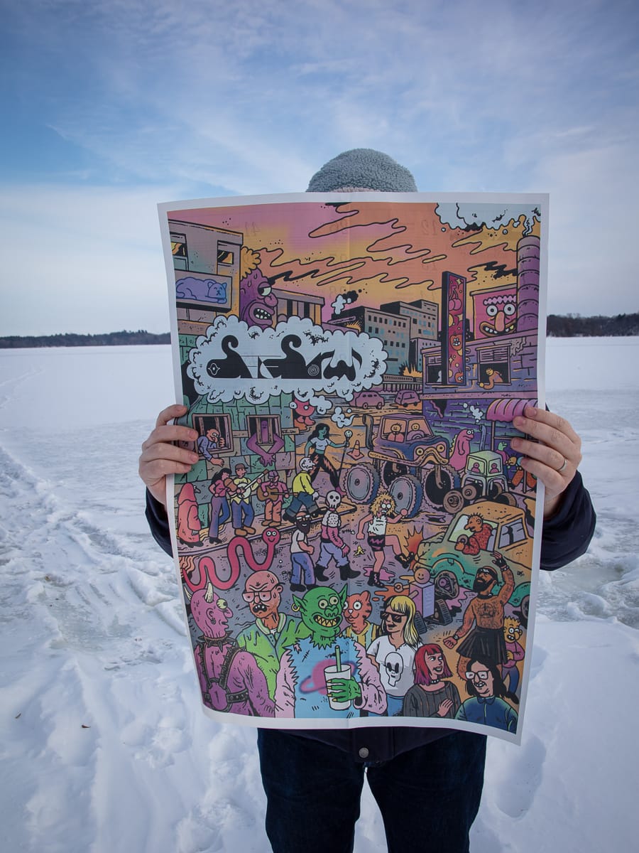 Evan Minsker holding see/saw's best of 2025 broadsheet, photo by Morgan Barrie