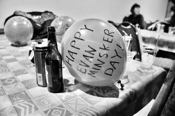 a balloon that reads HAPPY EVAN MINSKER DAY! leaning against some beers