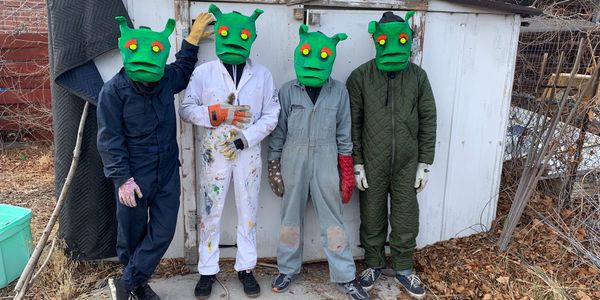 The band Rotary Club wearing papier mache goblin masks