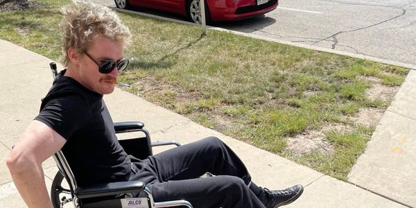 Beer’s Dakota in a wheelchair outside a Milwaukee emergency room, photo courtesy the band