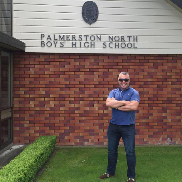 Matt Ratana posing outside his old school in a photo taken in 2017. Photo / Facebook