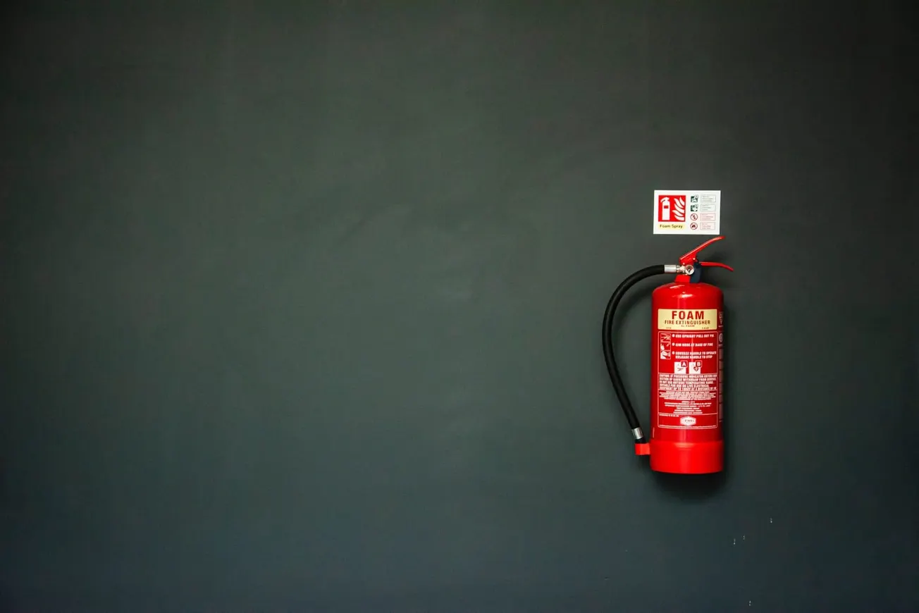 red fire extinguisher on gray wall
