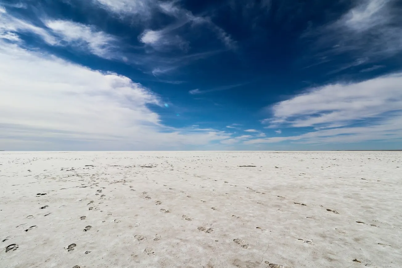 a vast expanse of white sand with footprints in the sand