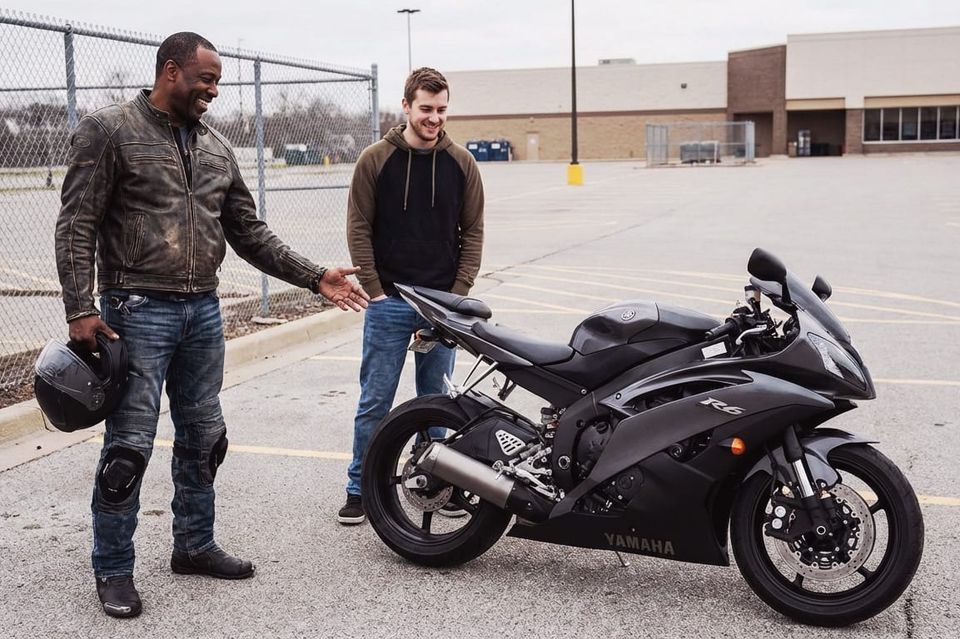 Man showing a sport motorcycle to a prospective buyer