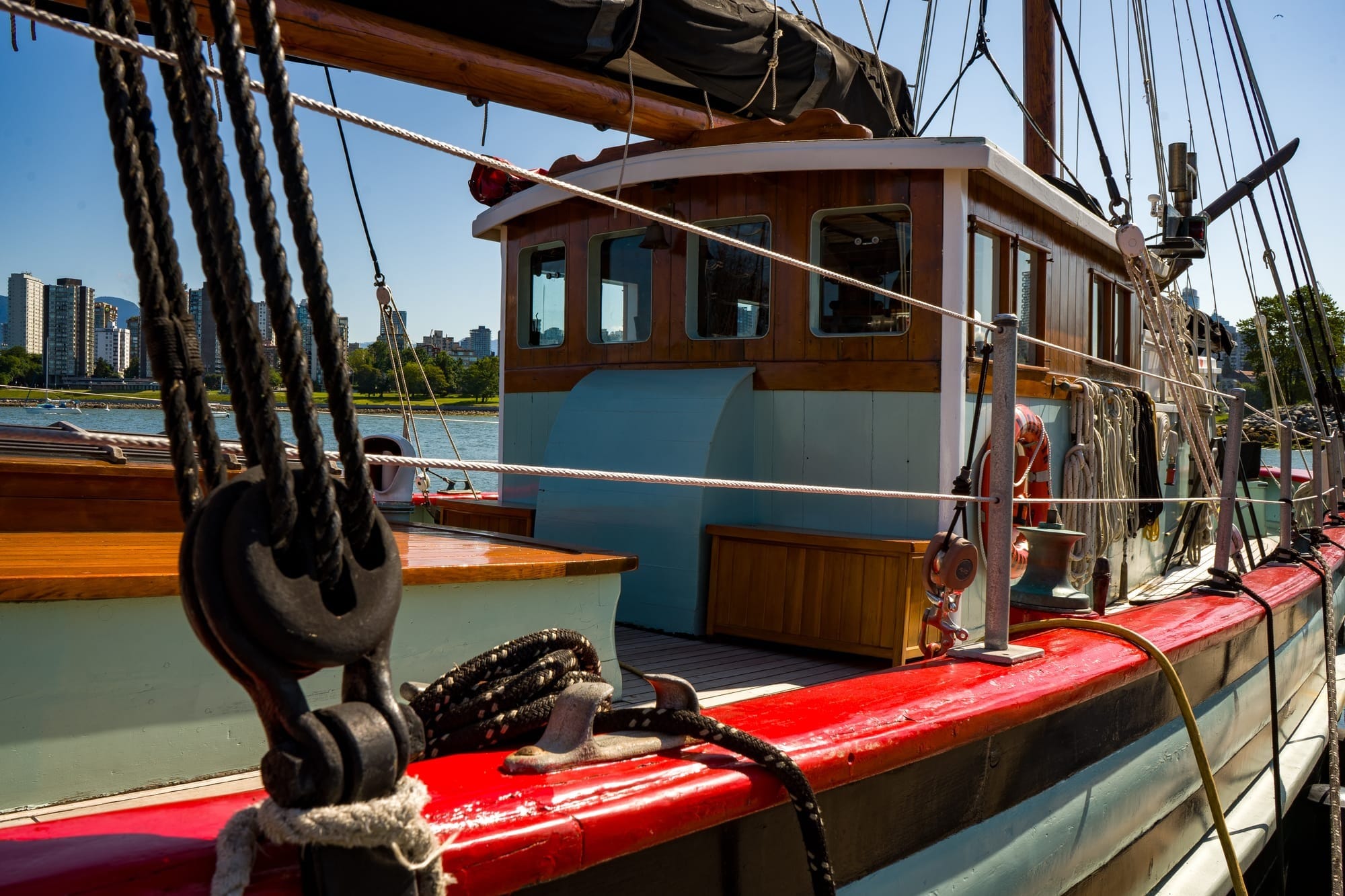 A wooden sailing vessel with fresh red, teal and black paint.