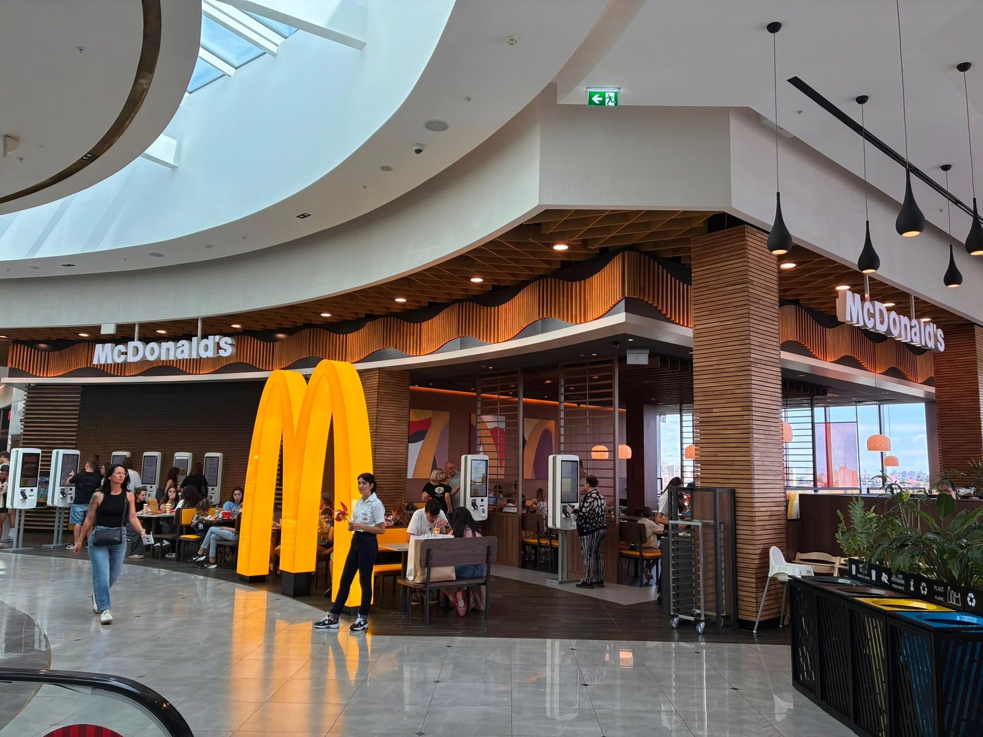 Логотип McDonald's как элемент пространственного зонирования ресторана на фудкорте