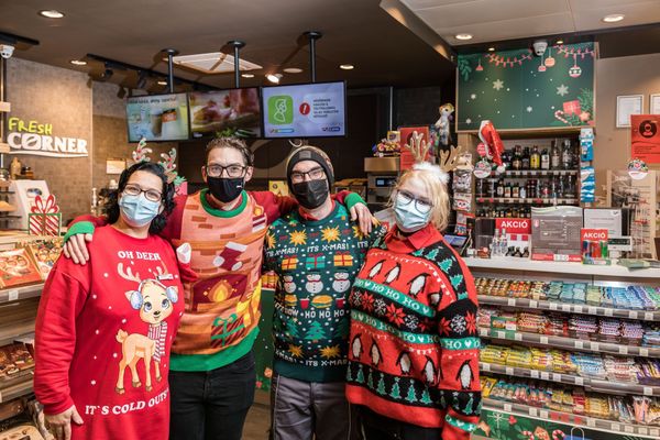 Гирлянды, сияющие огнями елки и сотрудники АЗС в рождественских свитерах