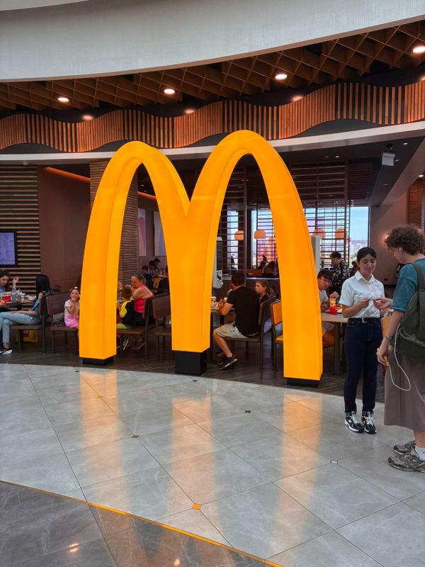 Логотип McDonald's как элемент пространственного зонирования ресторана на фудкорте