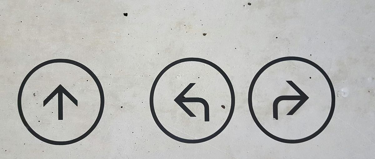 Three arrows on a concrete wall, each pointing a different direction — a visual reminder that when one path isn't working, others are always available.