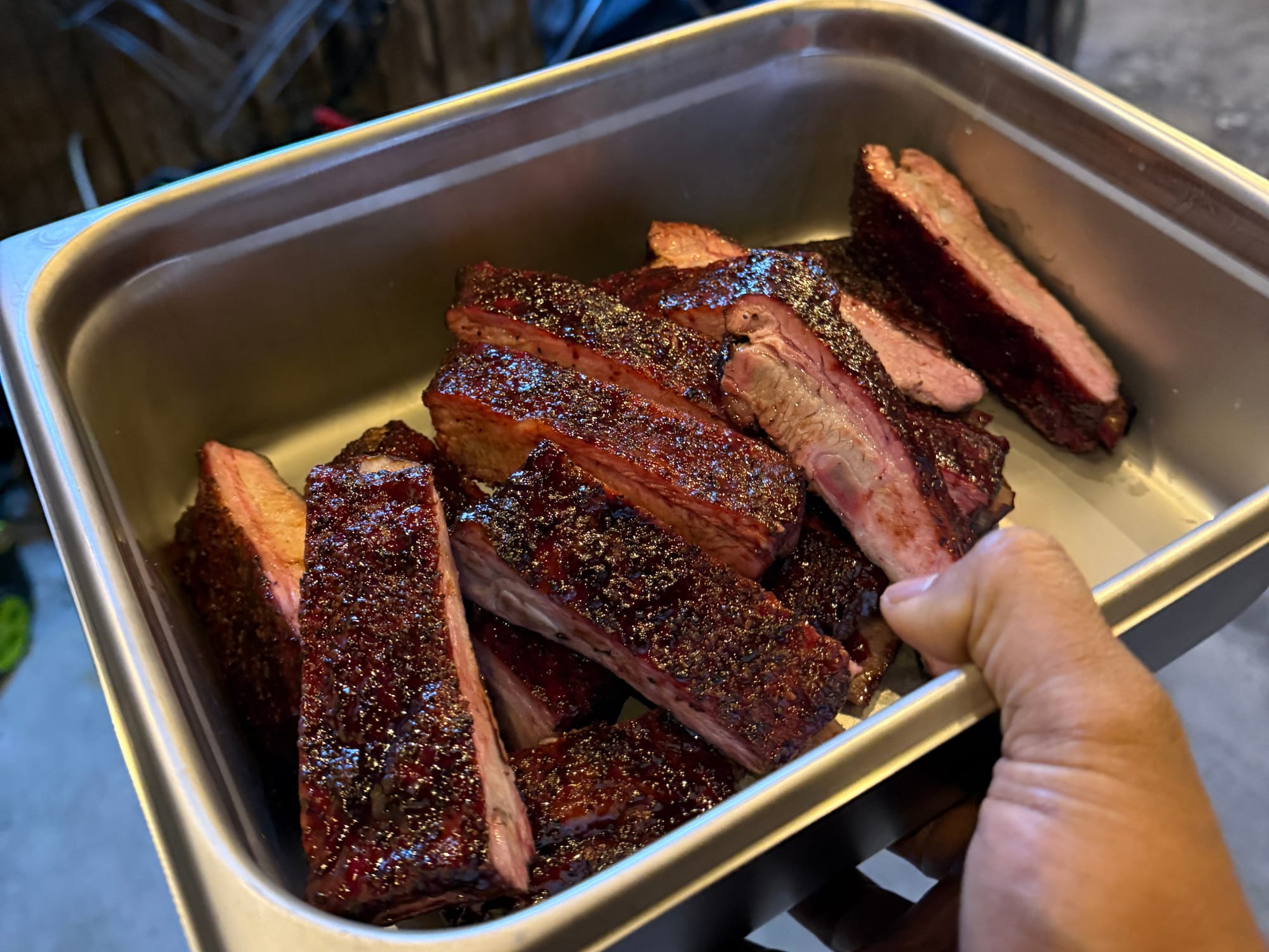 A metal container full of smoked ribs