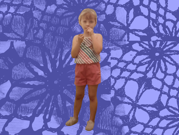 A young child in pink shorts and a rainbow top without sleeves.