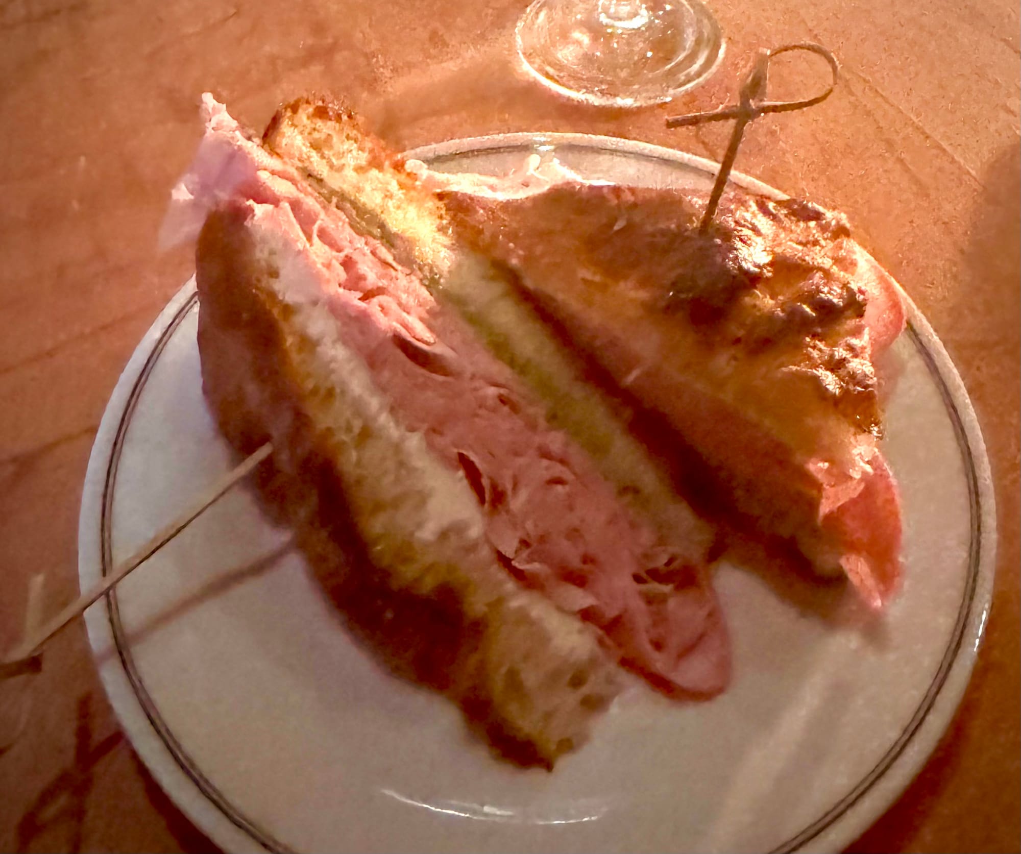 A thick mortadella sandwich served on a white plate